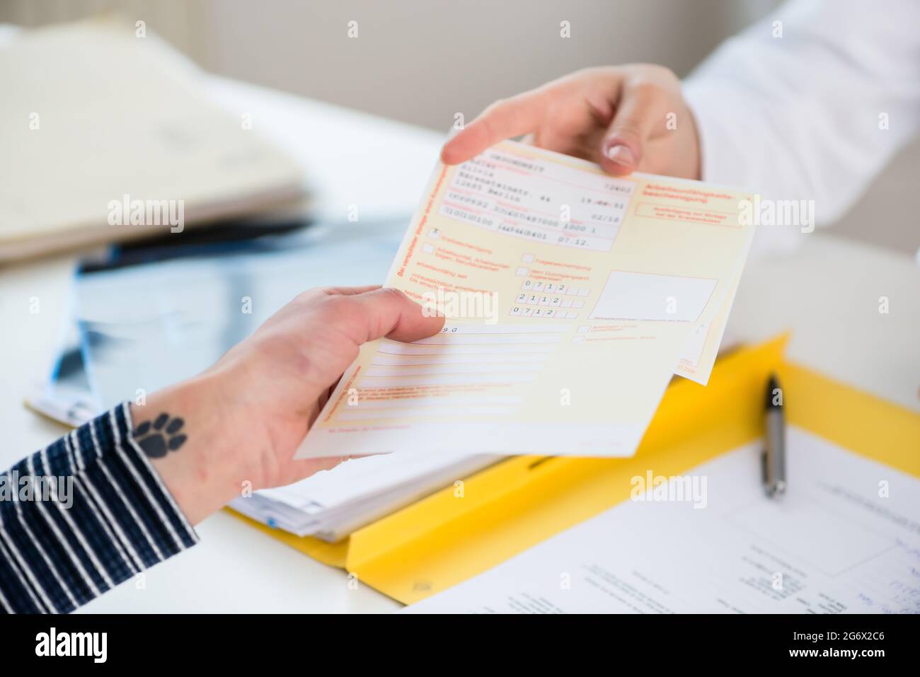 Close-up of the hand of a female patient receiving a printed medical prescription from the primary care  physician Stock Photo