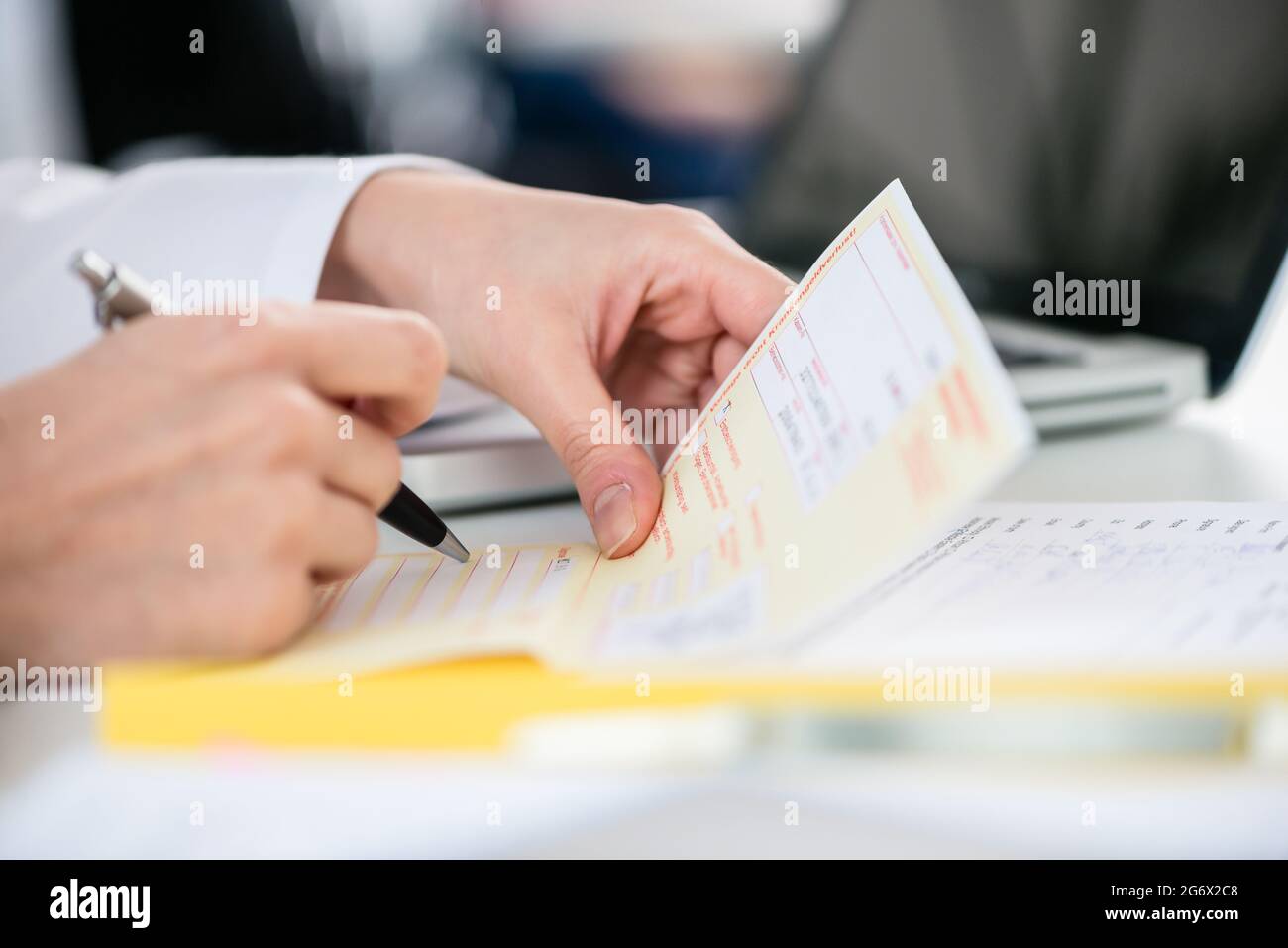 Close-up of the hand of a female patient receiving a printed medical prescription from the primary care  physician Stock Photo