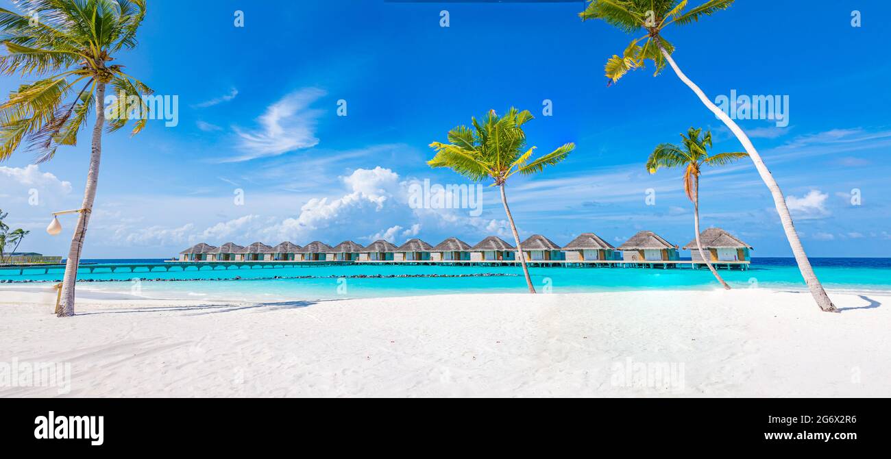 Idyllic tropical beach landscape with water villas and bungalows. Design of tourism summer vacation holiday destination concept. Luxury island beach Stock Photo