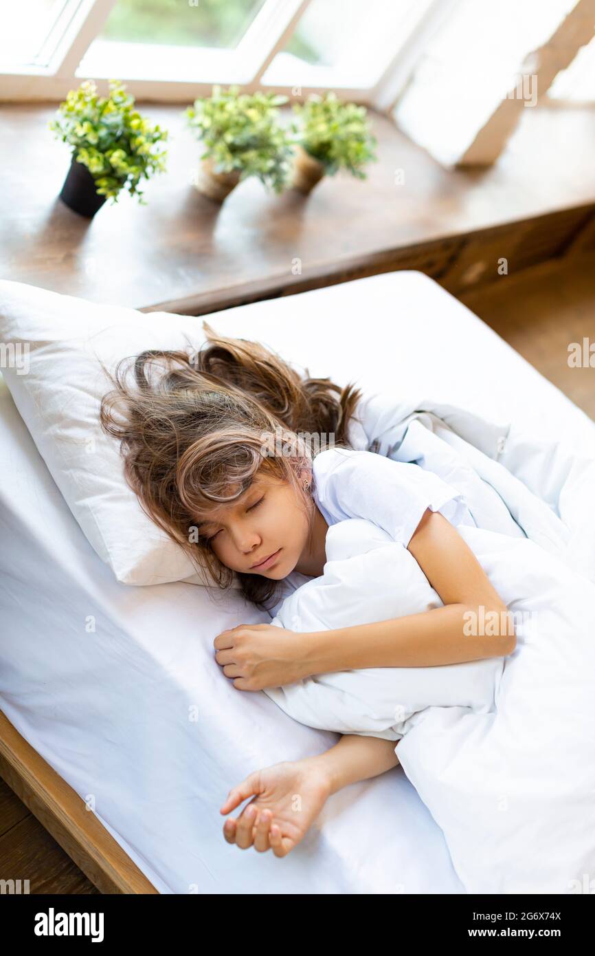 Vertical photo of a 10 year old girl sleeping under a blanket before awakening Stock Photo Alamy