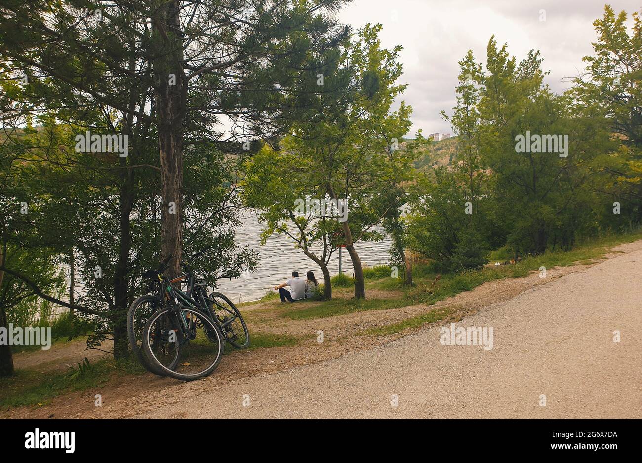 Ankara; Turkey-July 04; 2021: Couple sitting by the lakeside and viewing beautiful view and in Lake Eymir in Ankara. People getting used to new normal. Stock Photo