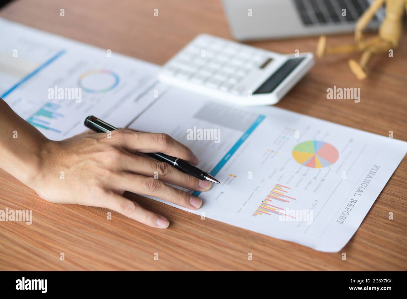 Close up of analysts team working on their financial report with calculator and laptop on wooden table. Stock Photo