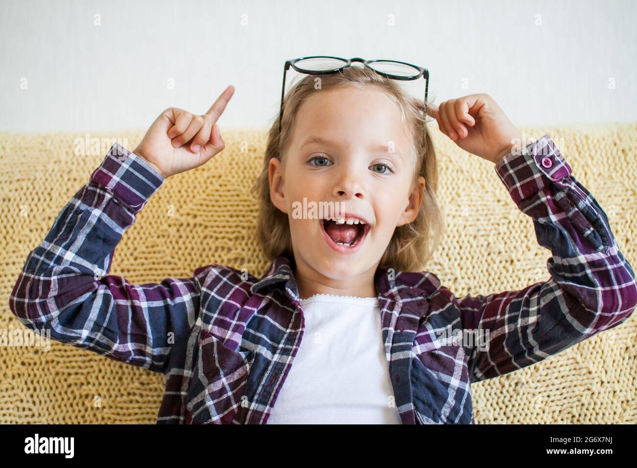 Cheerful girl in a plaid shirt and glasses. Online learning concept. Stock Photo