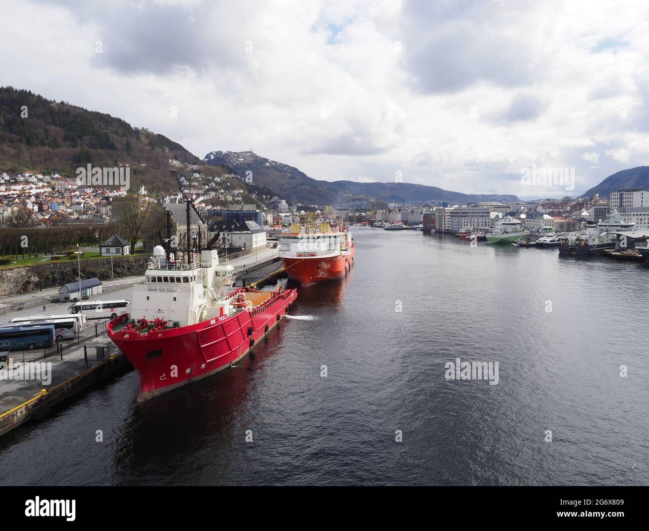 The port of Bergen in Norway with cruise ships and commercial shipping moored and the city on the hills behind Stock Photo