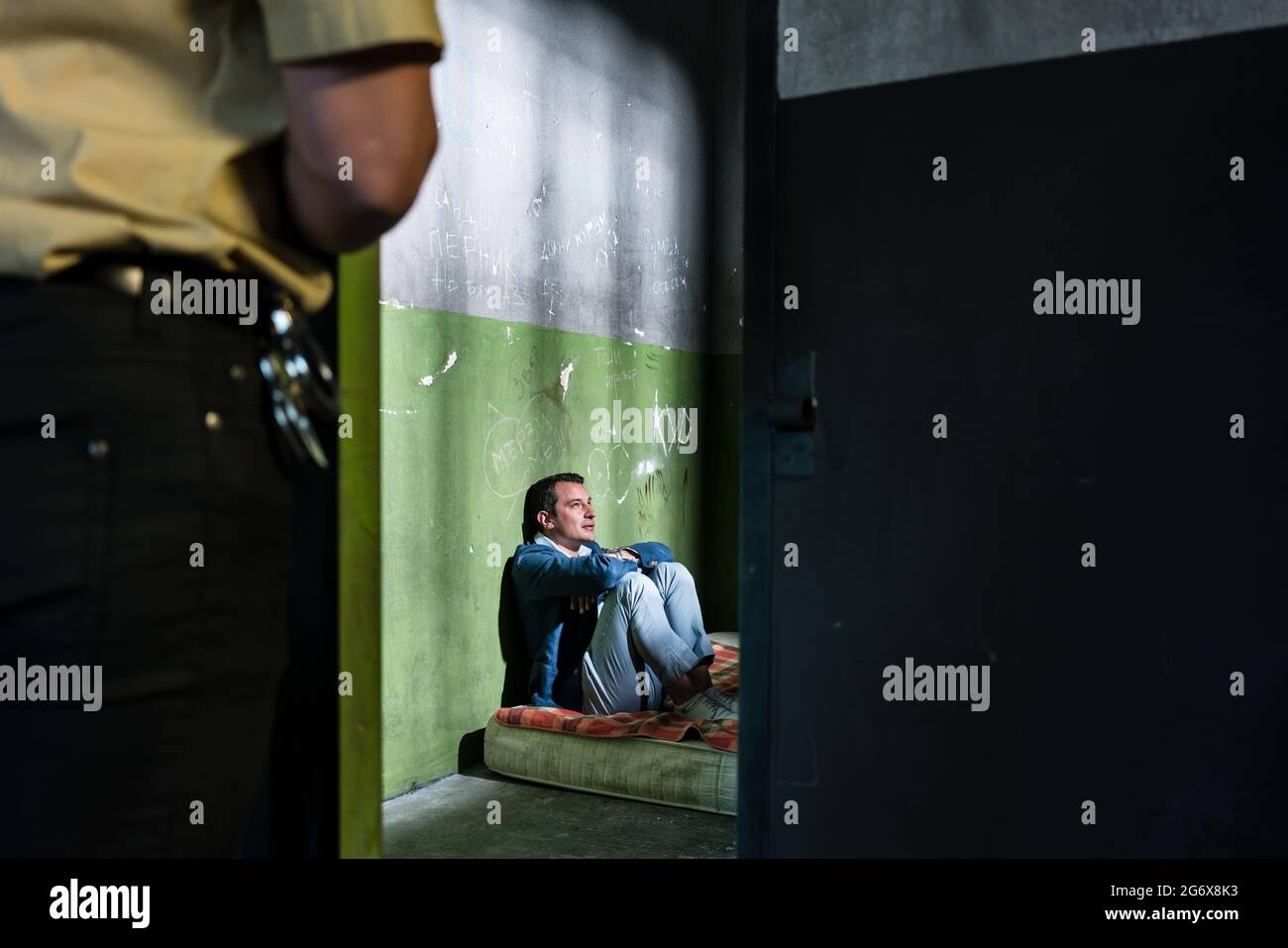 Side view of a young male prisoner thinking while sitting alone on a
