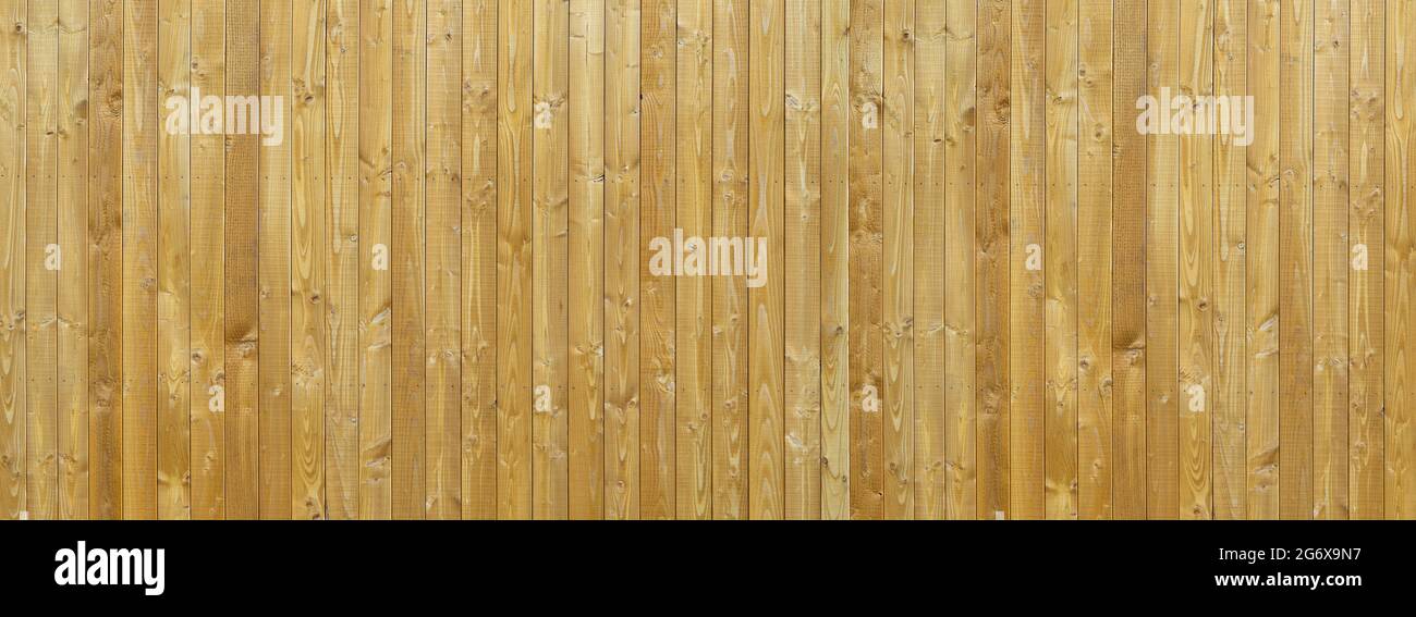 New wooden wall made of light brown, grained, vertical boards Stock Photo
