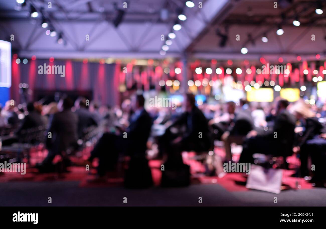 Anonymized photo with blurred out audience at a conference listening to ...