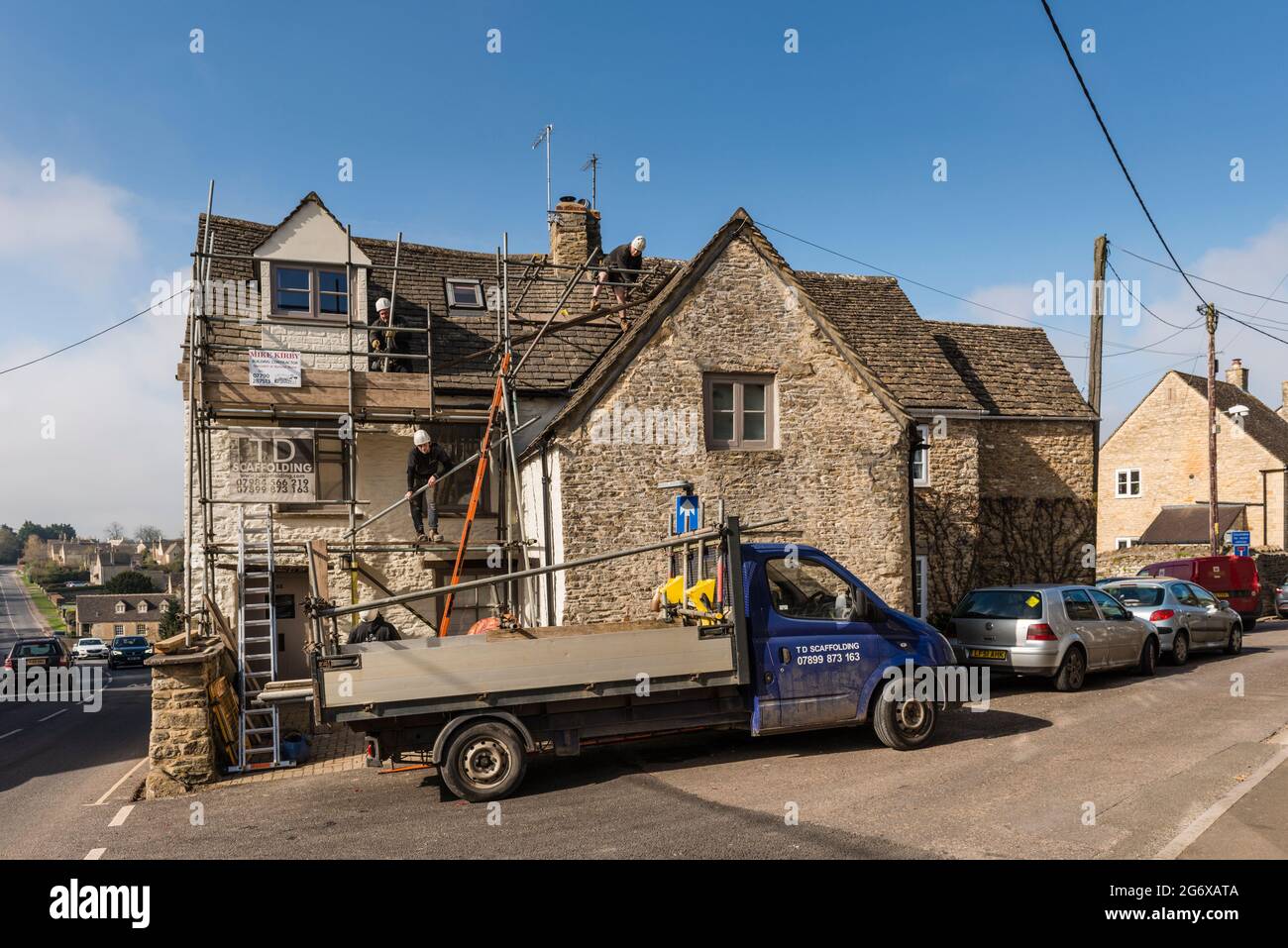 Workmen put up scafoldings to Cotswold cottage, Tetbury, Gloucestershire, uk Stock Photo