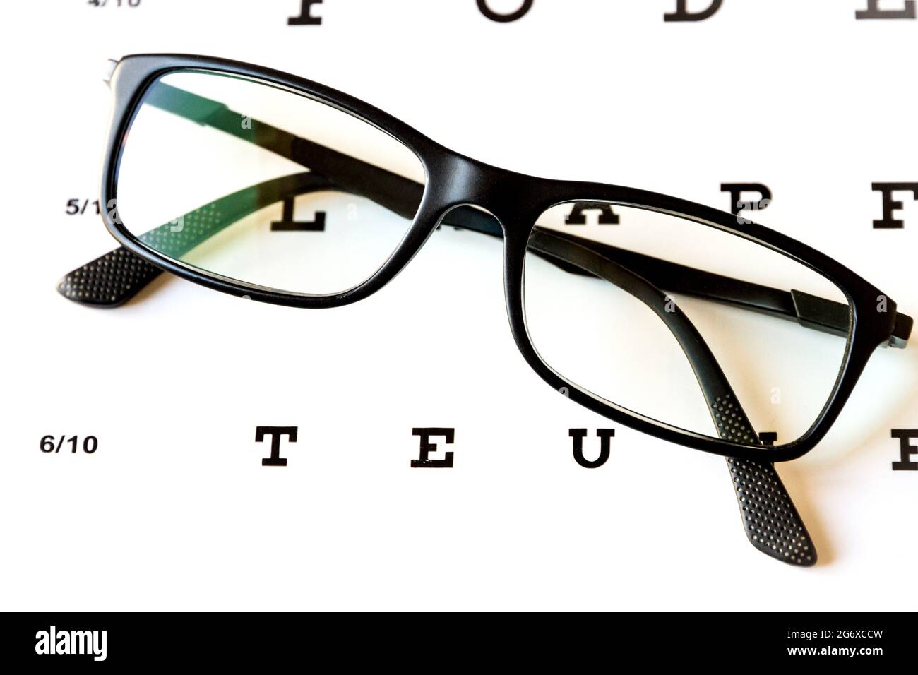 Glasses on eye chart. Optical device background Stock Photo Alamy