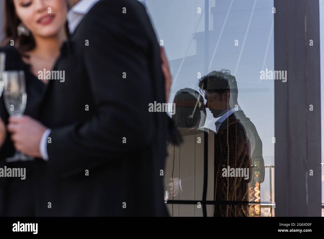 silhouette of loving couple in glass of window with blurred foreground Stock Photo