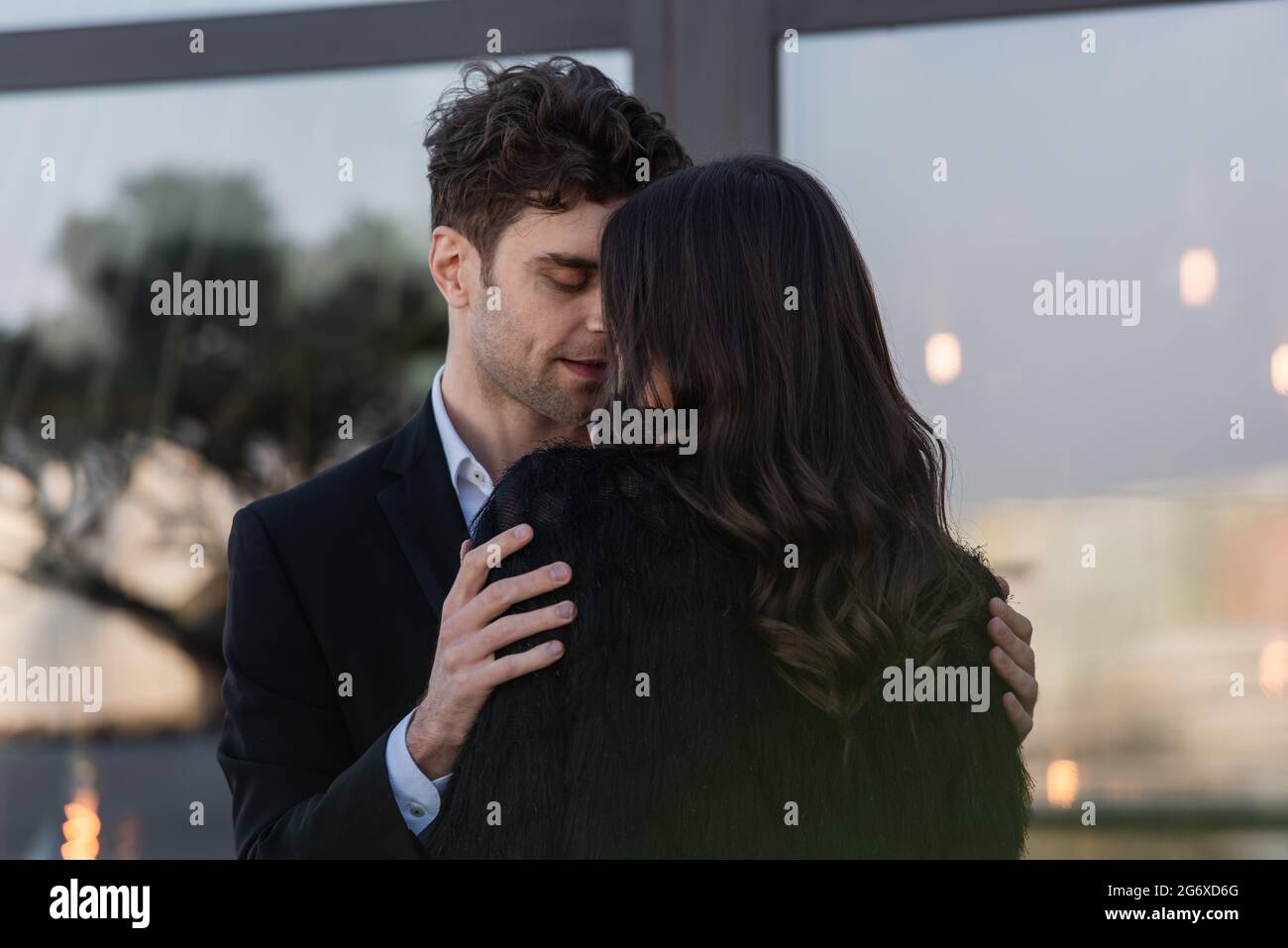 man hugging brunette woman in faux fur jacket outdoors Stock Photo - Alamy