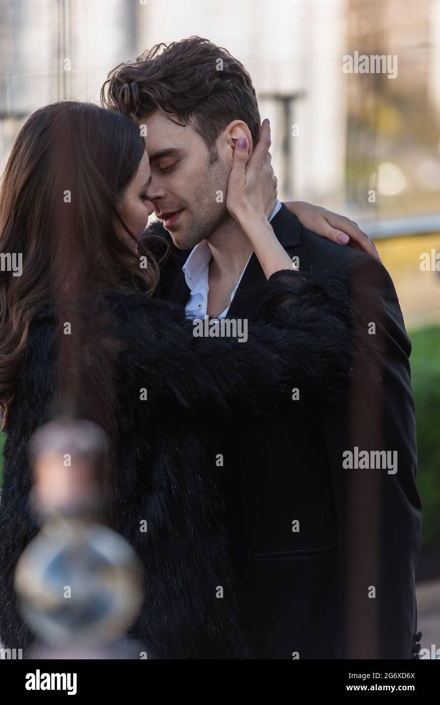 woman in faux fur jacket embracing man in suit outdoors Stock Photo - Alamy