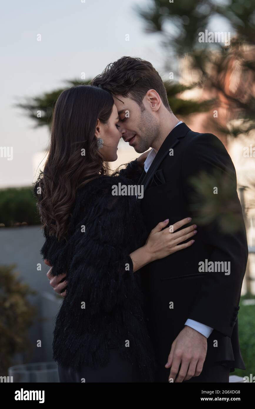 elegant man and woman in faux fur jacket hugging against blue sky Stock ...