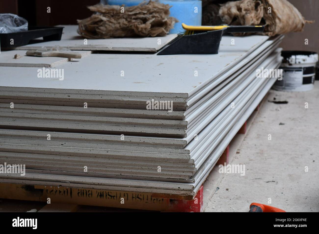 Sheets of plasterboard stacked on a building site with insulation, a