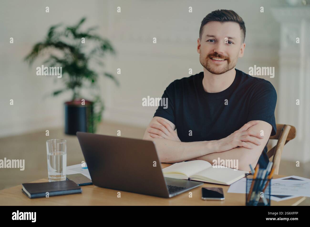 Handsome successful freelancer working with laptop at his workplace Stock Photo