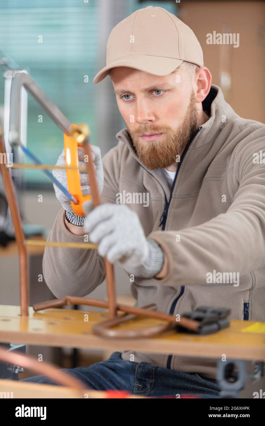 workman using hacksaw on copper pipe Stock Photo Alamy