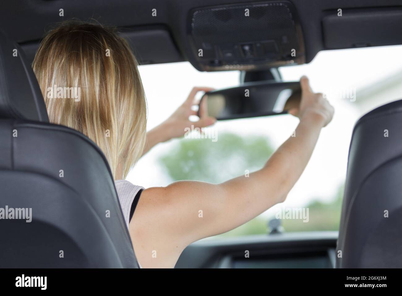 Adjusting the rear view mirror of a car hires stock photography and
