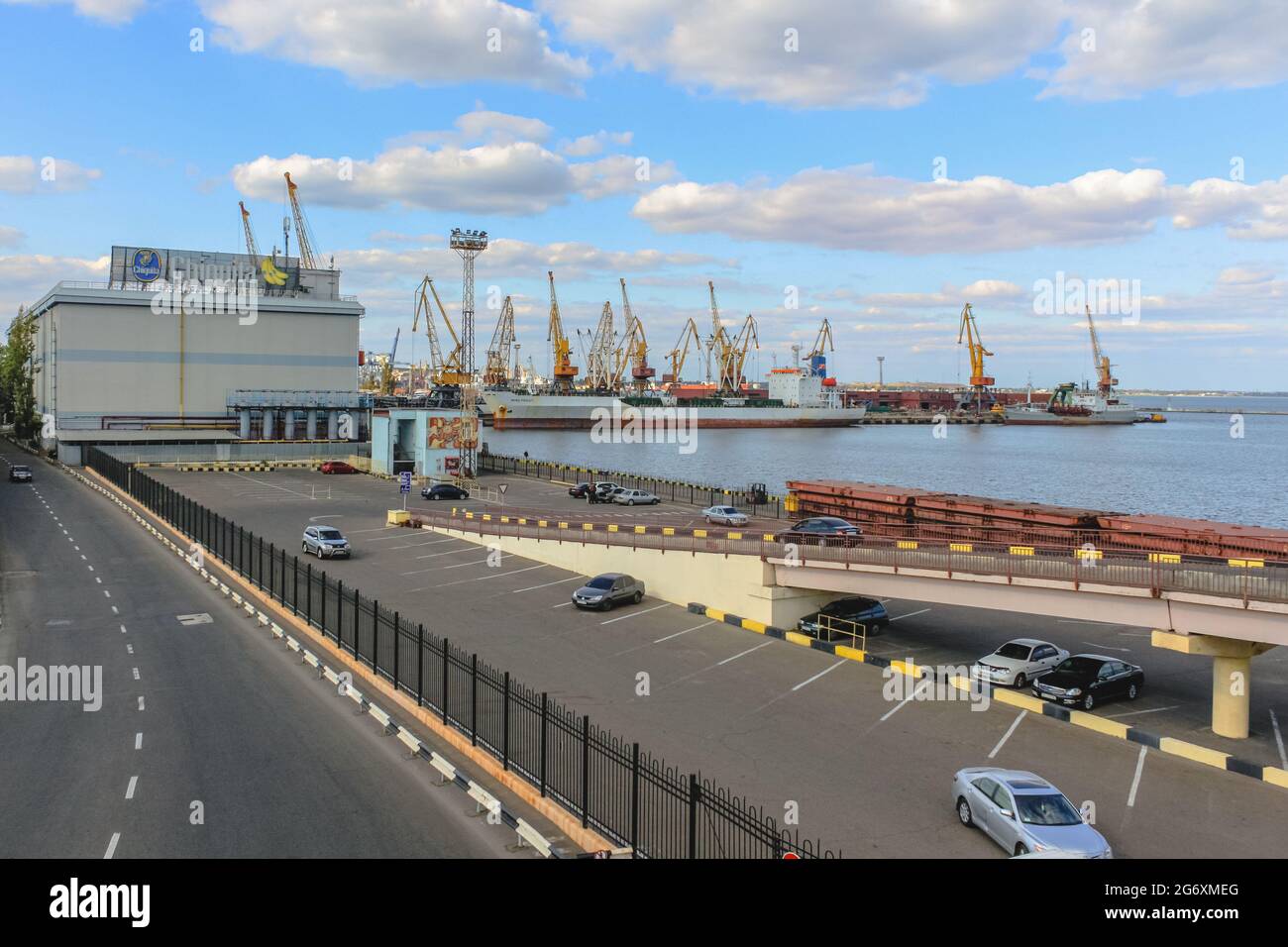 Odessa, Ukraine, October 9, 2012: The building of the Odessa commercial sea port with cranes, a ship and a parking lot in the foreground Stock Photo