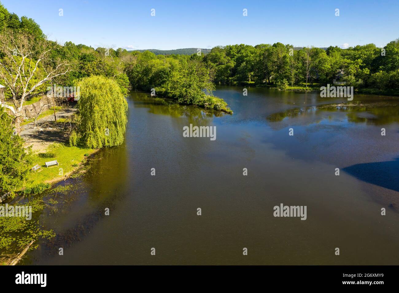 Aerial of river in Clinton, New Jersey, with green trees and a weeping willow tree near the water's edge. Stock Photo
