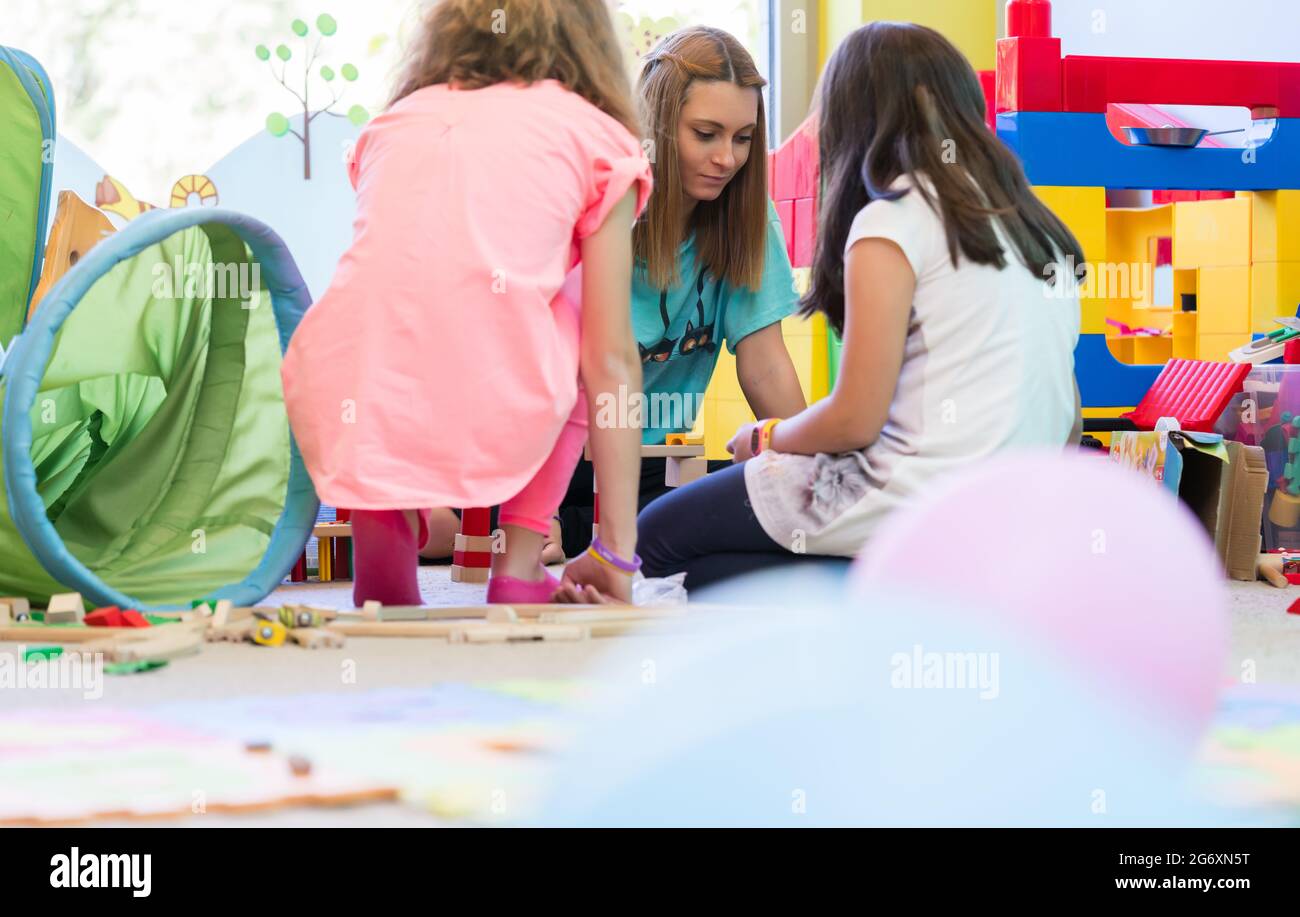 Young dedicated kindergarten teacher coordinating a fun activity for