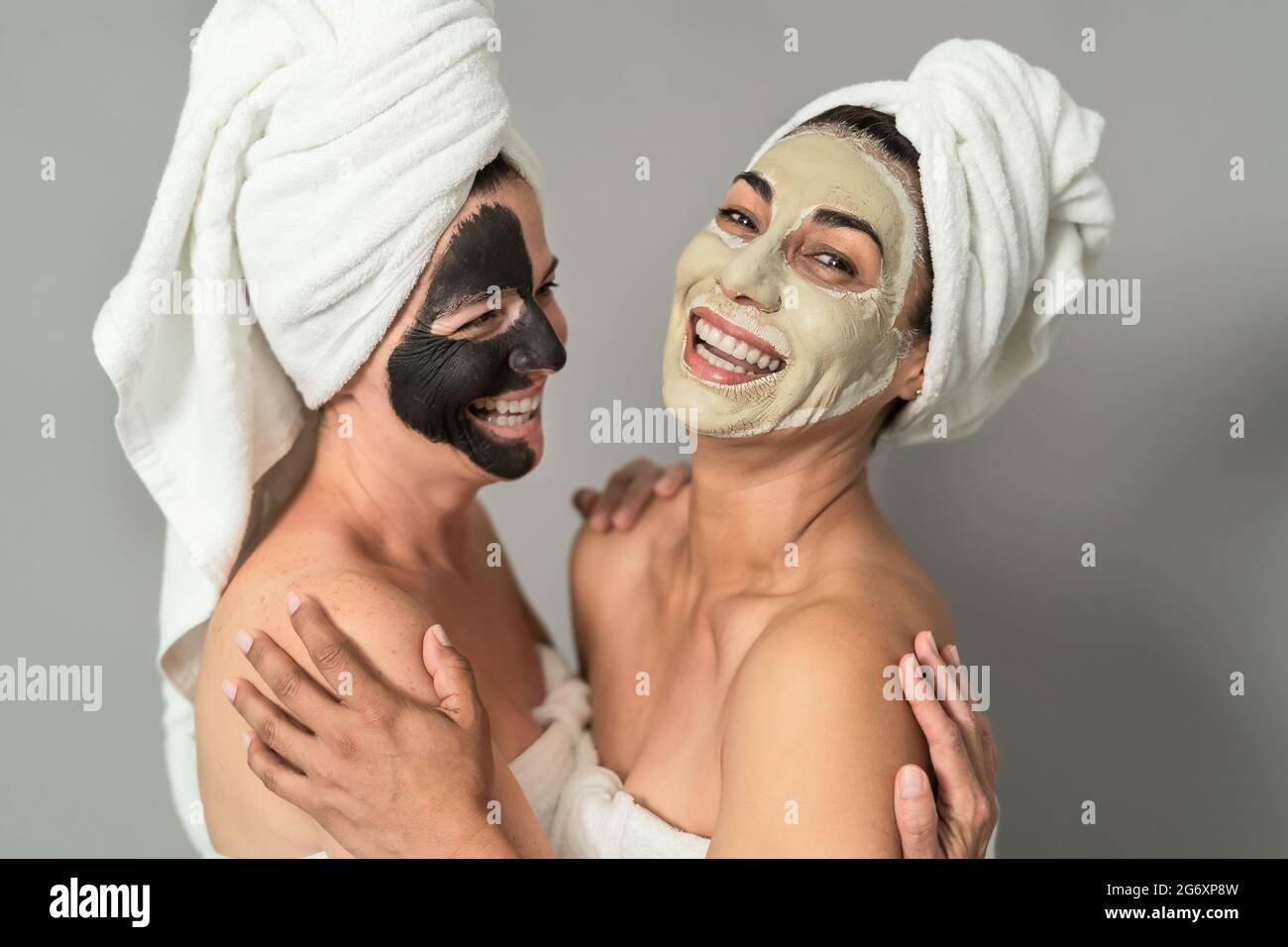 Happy middle age women with facial mask having skin care spa day - People selfcare lifestyle concept Stock Photo
