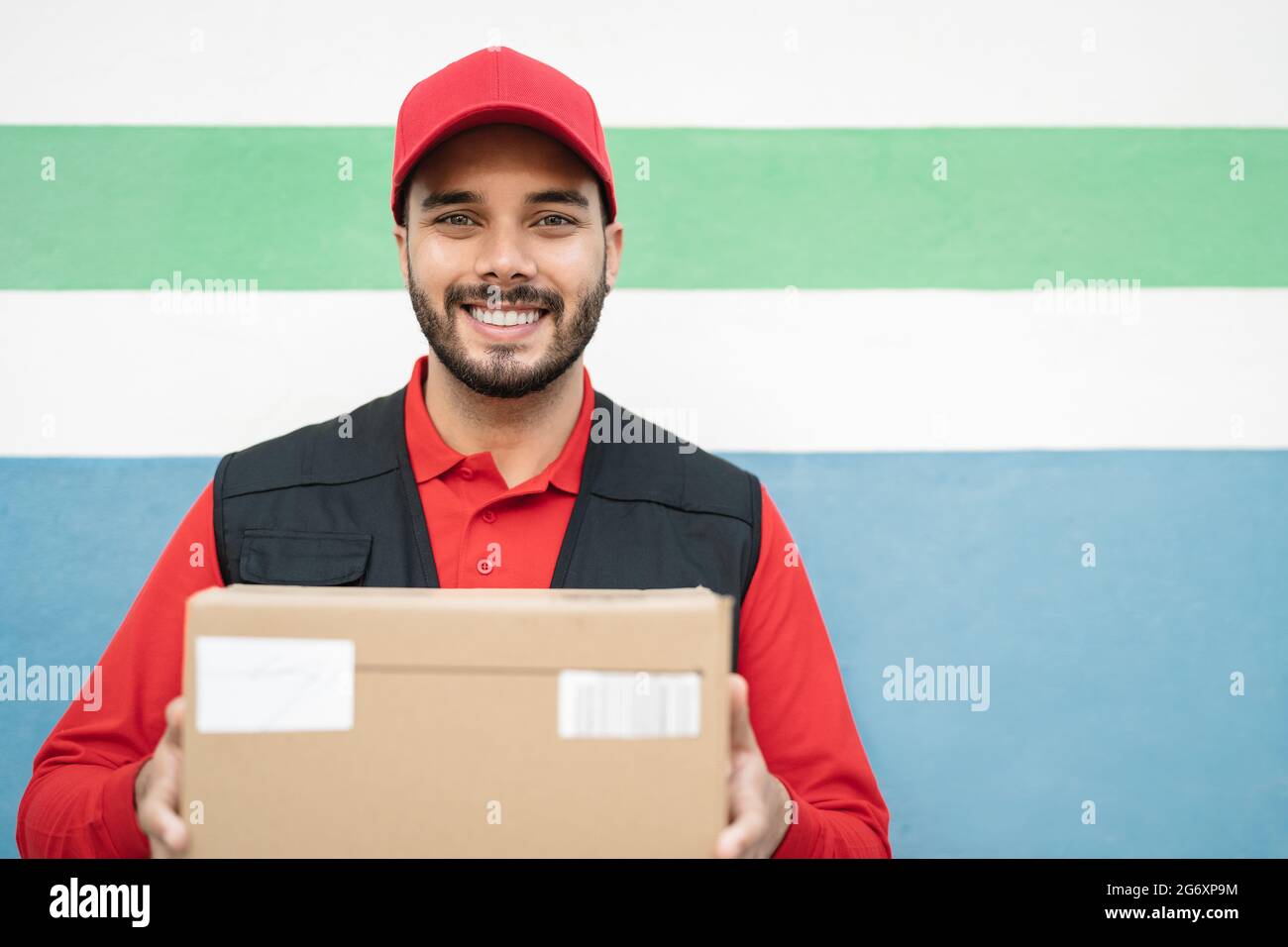 Young delivery man carrying cardboard box - People working with fast deliver transportation Stock Photo