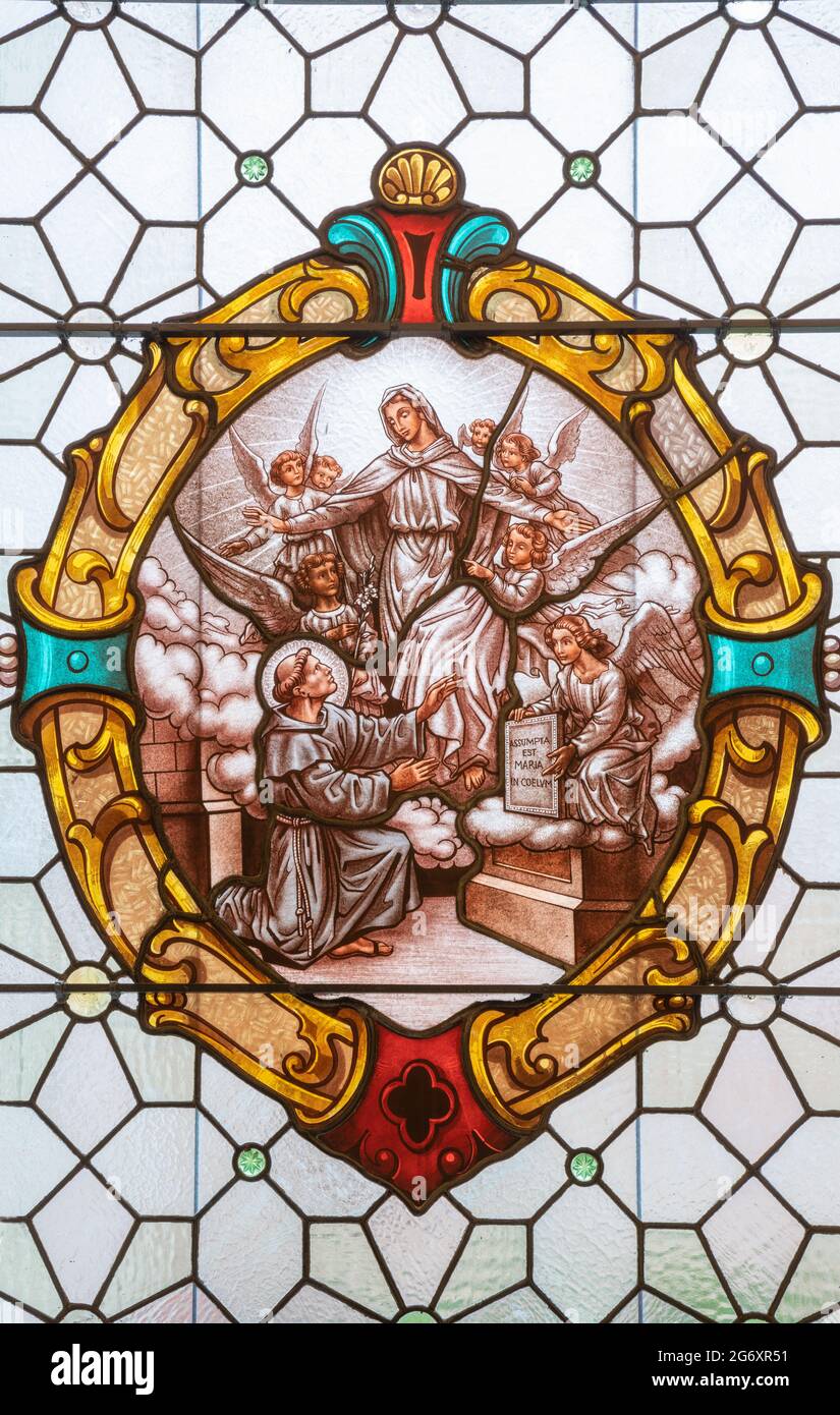 VIENNA, AUSTIRA - JUNI 17, 2021: The Vision of Vision of Virgin Mary to St. Anthony of Padua on the stained glass of church  Alserkirche Stock Photo