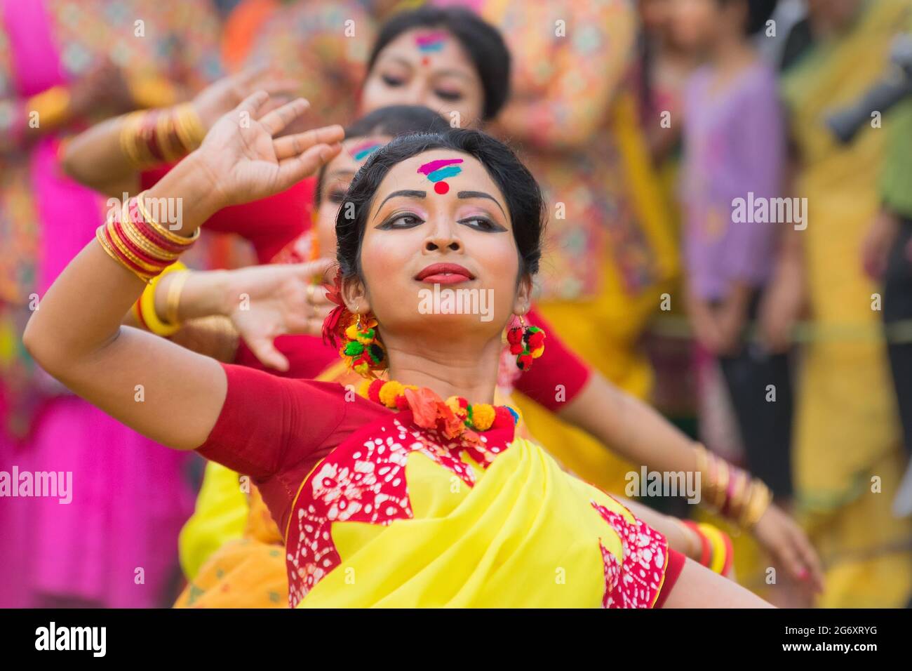 KOLKATA , INDIA - MARCH 12, 2017: Dancing poses of girl dancers , dressed in yellow and red coloured sari (traditional Indian dress) dancing at Spring Stock Photo