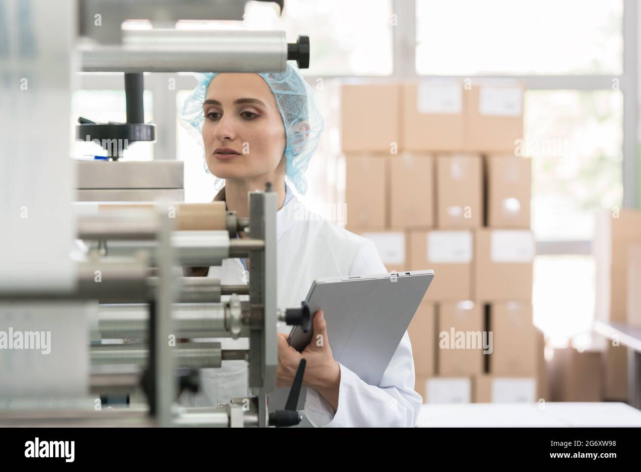 Female manufacturing supervisor looking worried while checking ...