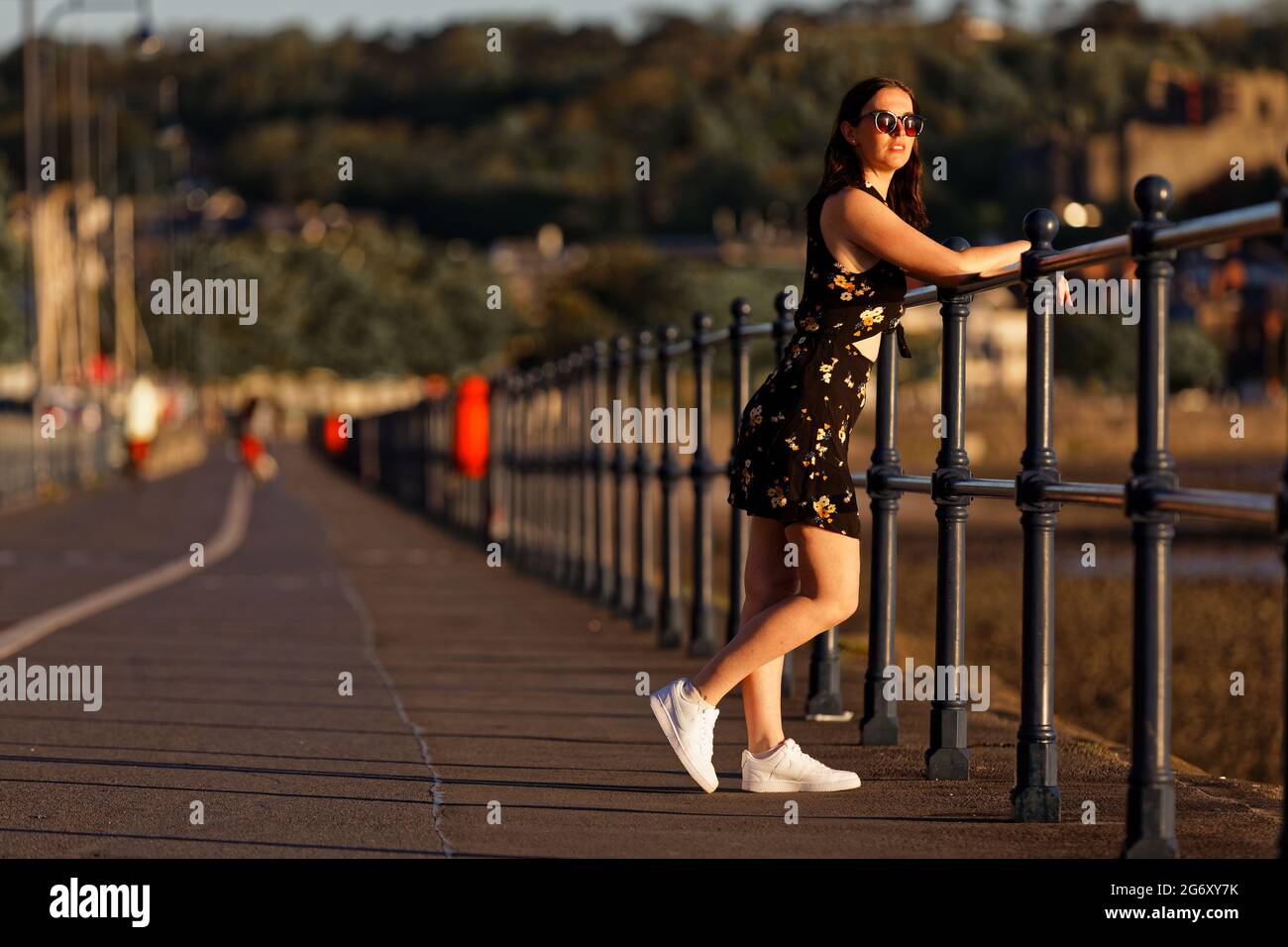 Pictured: Natasha Jenkins takes a stroll during sunrise in Mumbles promenade, near Swansea, Wales, UK. Sunday 13 June 2021 Re: High temperatures and s Stock Photo
