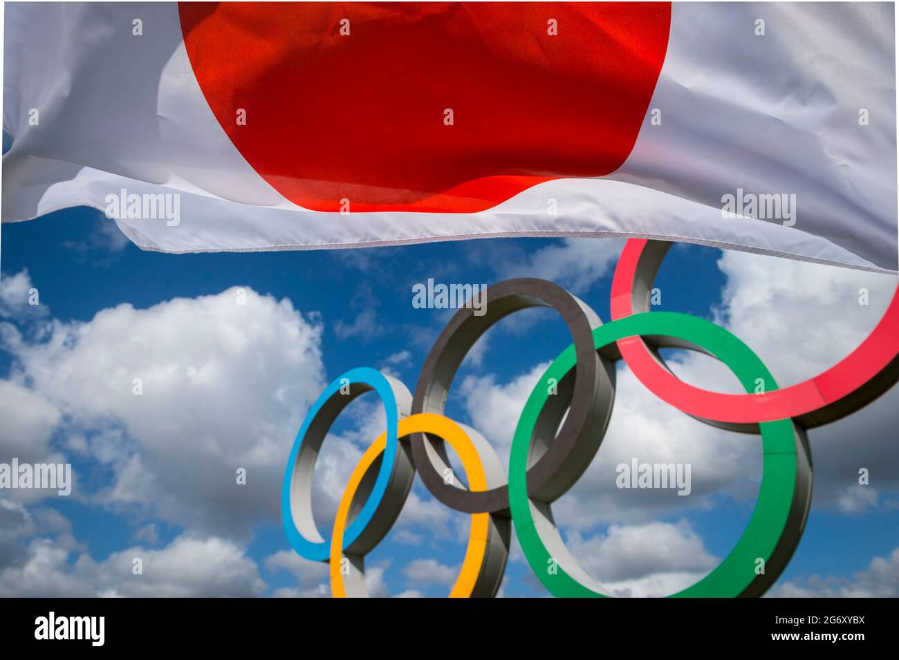 RIO DE JANEIRO - MARCH, 2016: A Japanese flag flutters in the wind in front of Olympic Rings standing under bright blue sky. Stock Photo