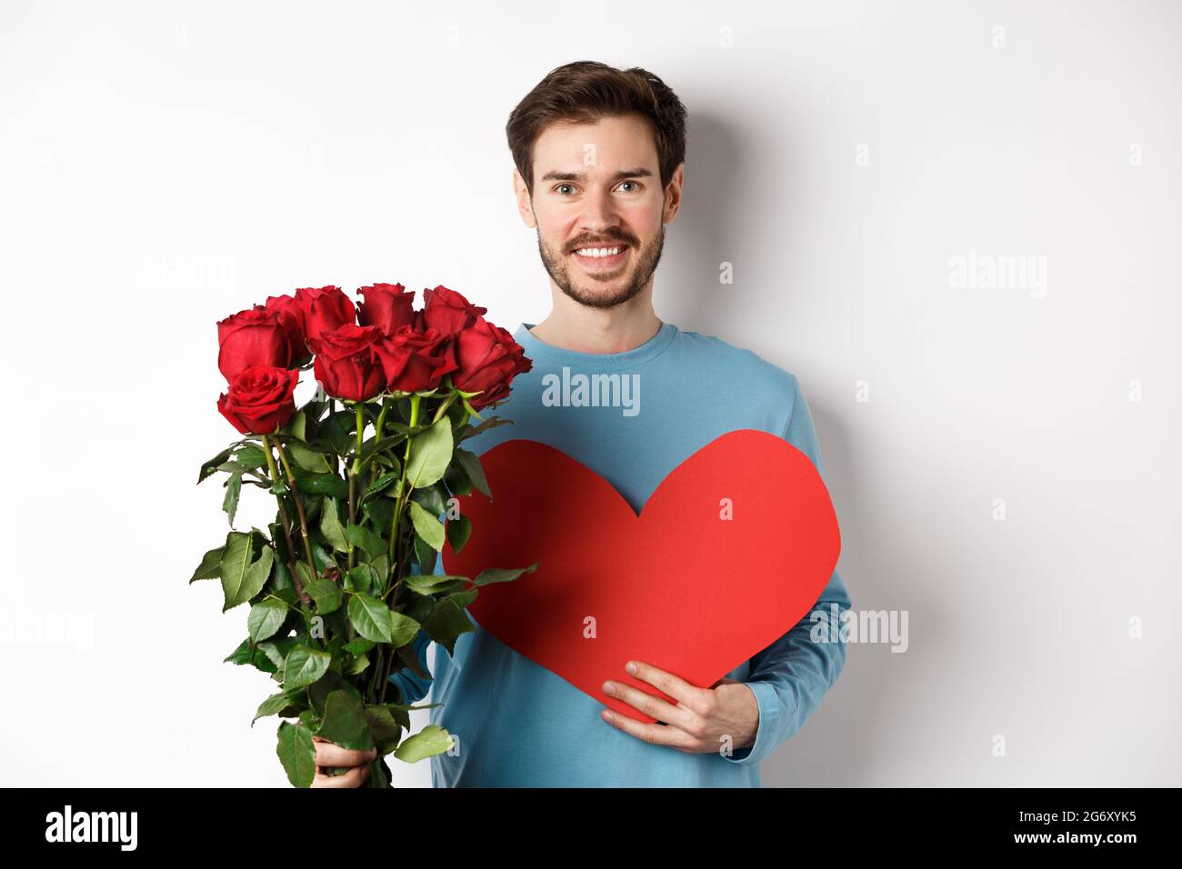 Romantic people. Handsome smiling man holding bouquet of roses and big ...