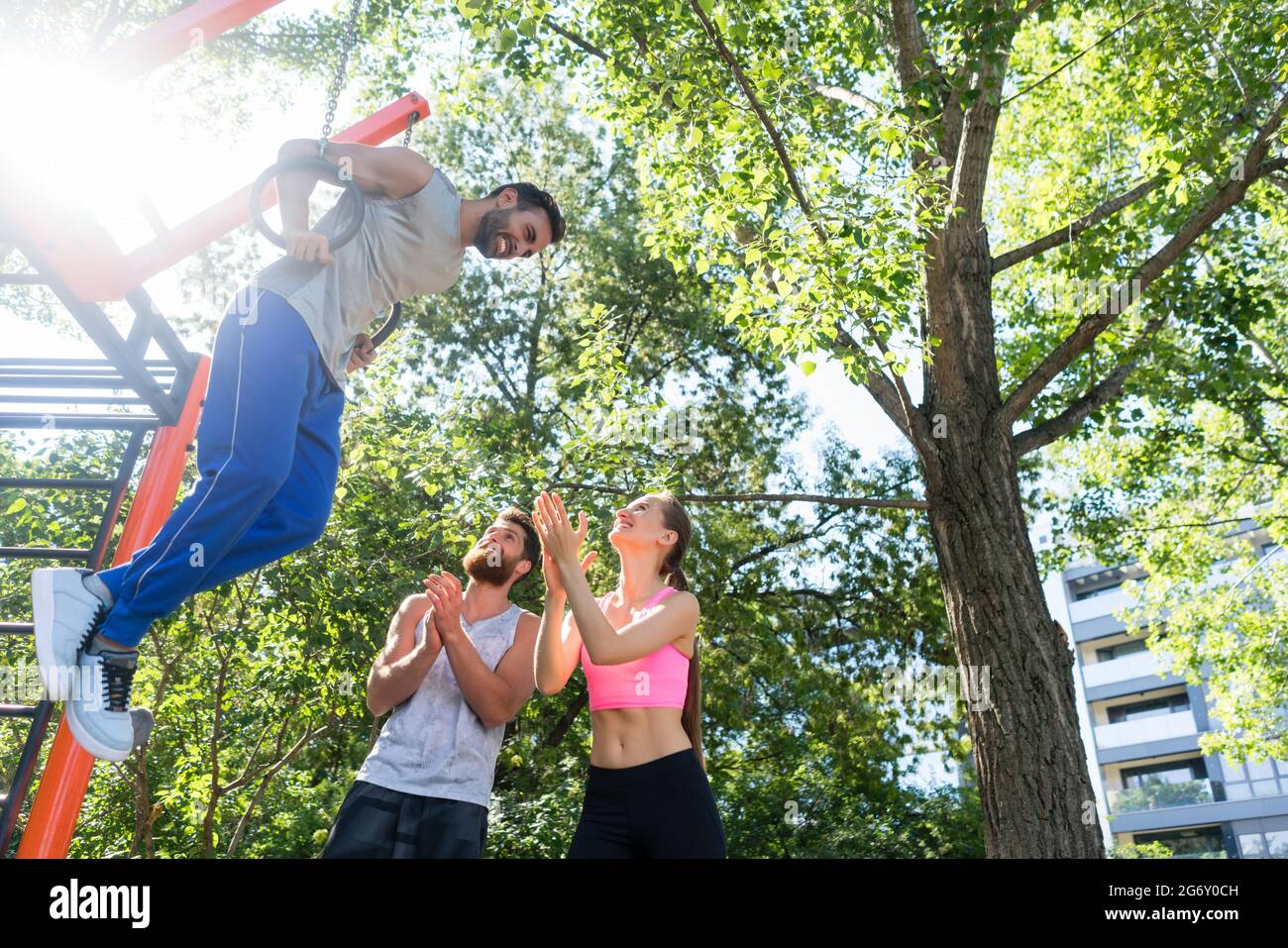 Lowangle view of a strong young man doing difficult dip exercise for triceps on gymnastic rings