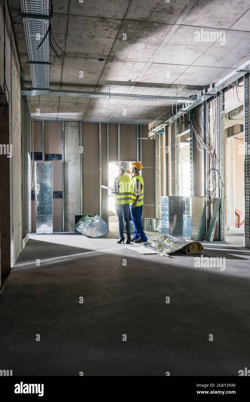 Interior construction works in a building being inspected by two ...