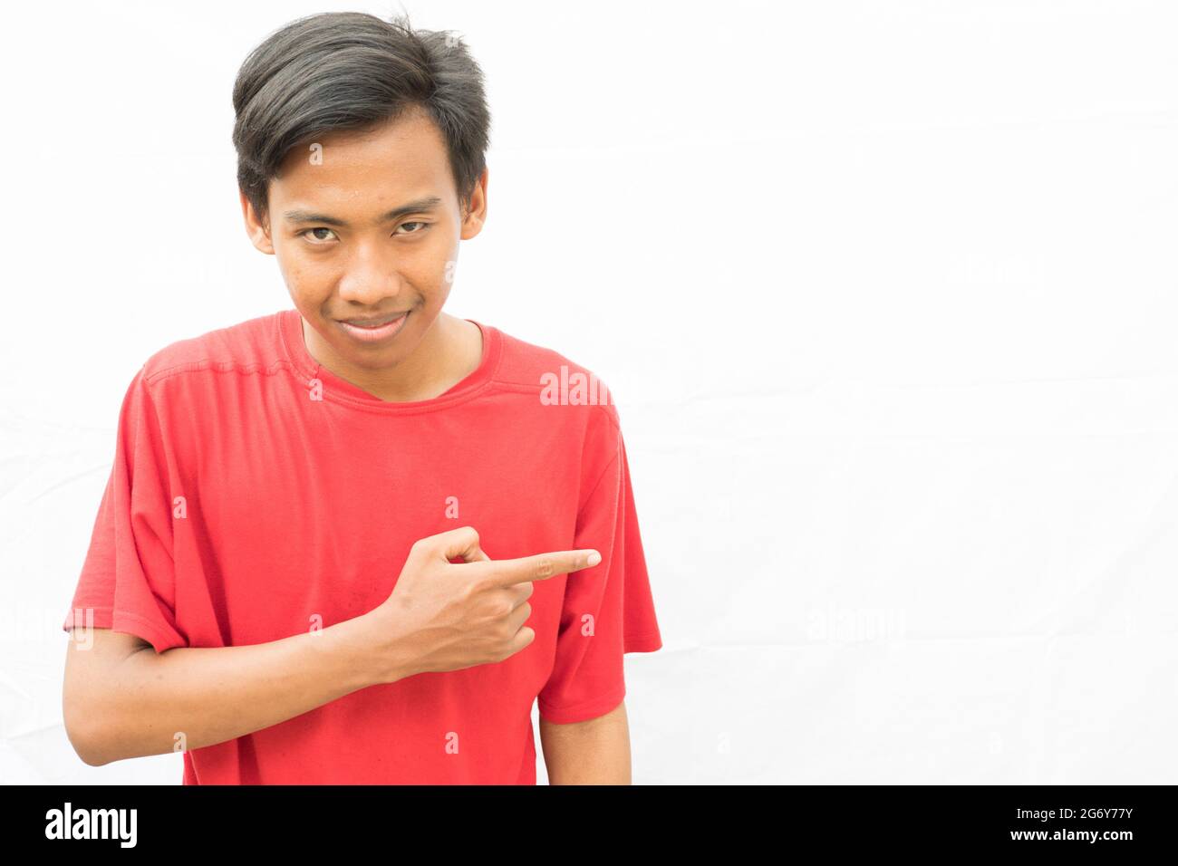 Young Indonesian guy a red t-shirt the right of the photo for your text Stock Photo - Alamy