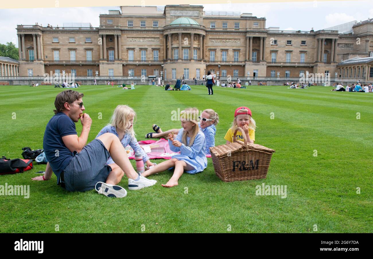London UK 9 July The Garden at Buckingham Palace . The Johnson -Hill family from Stockwell London picnicking with their Fortnum and Mason hamper in The Garden at Buckingham Palace on the first  day it opened to  the general public. They  were allowed to Explore Buckingham Palace Garden with unique access this summer, and discover for the very first time its sights before enjoying a unique, once-in-a-lifetime opportunity to picnic with views of the Palace. Credit Gary Blake /Alamy Live news Stock Photo