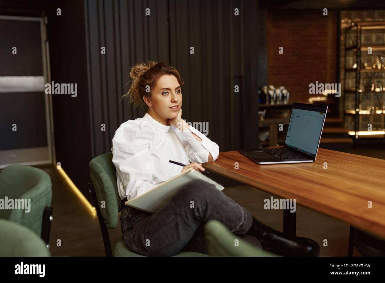 Woman using laptop while working at modern cafe Stock Photo