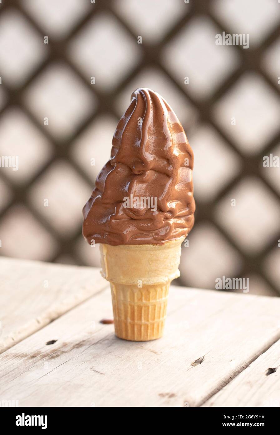 Chocolate Soft Serve Ice Cream Cone Melting in the Summer Heat Stock Photo