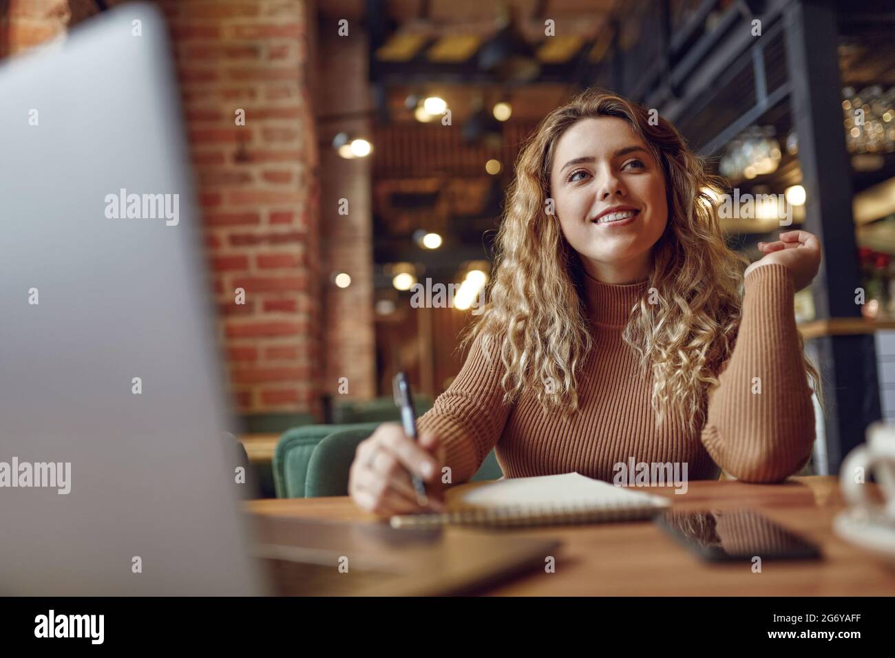 Woman sitting at a cafe table hi-res stock photography and images - Alamy