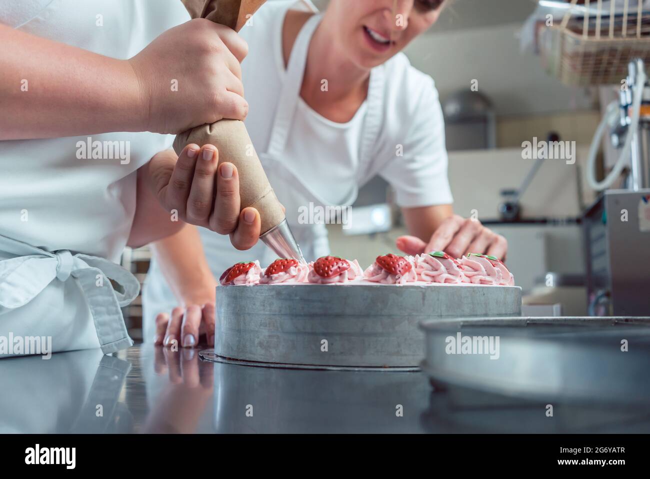 https://c8.alamy.com/comp/2G6YATR/confectioner-or-pastry-chefs-finishing-cake-with-pastry-bag-close-up-on-hands-2G6YATR.jpg