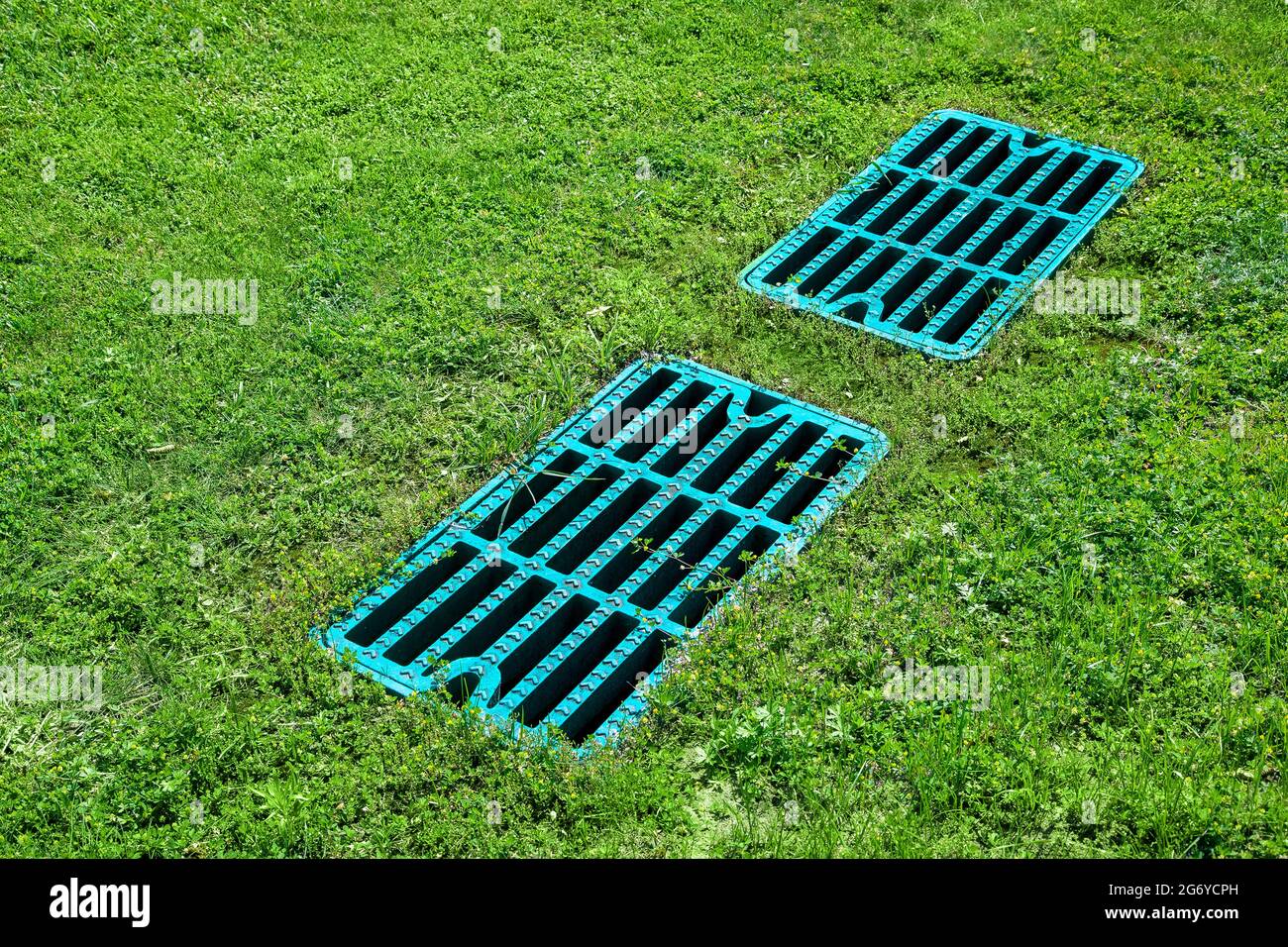 manhole drainage grates on the lawn with green grass septic tank cover, sump cesspool drainage system environment design side view with copy space, no Stock Photo