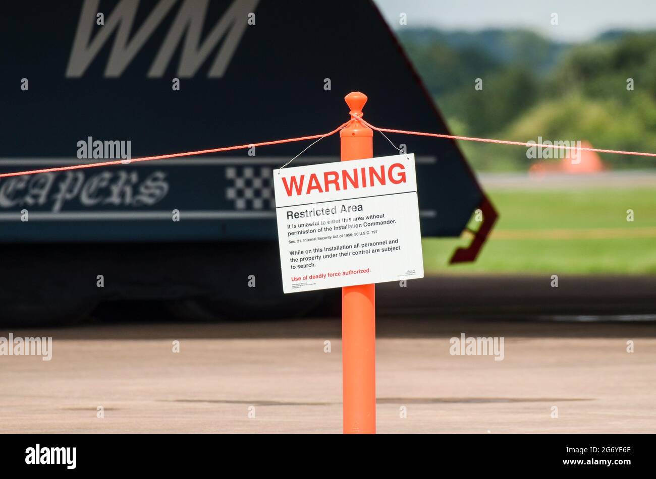 Northrop Grumman B-2 Spirit stealth bomber with armed security warning sign for restricted area at RIAT airshow. Lethal force authorised. No entry Stock Photo