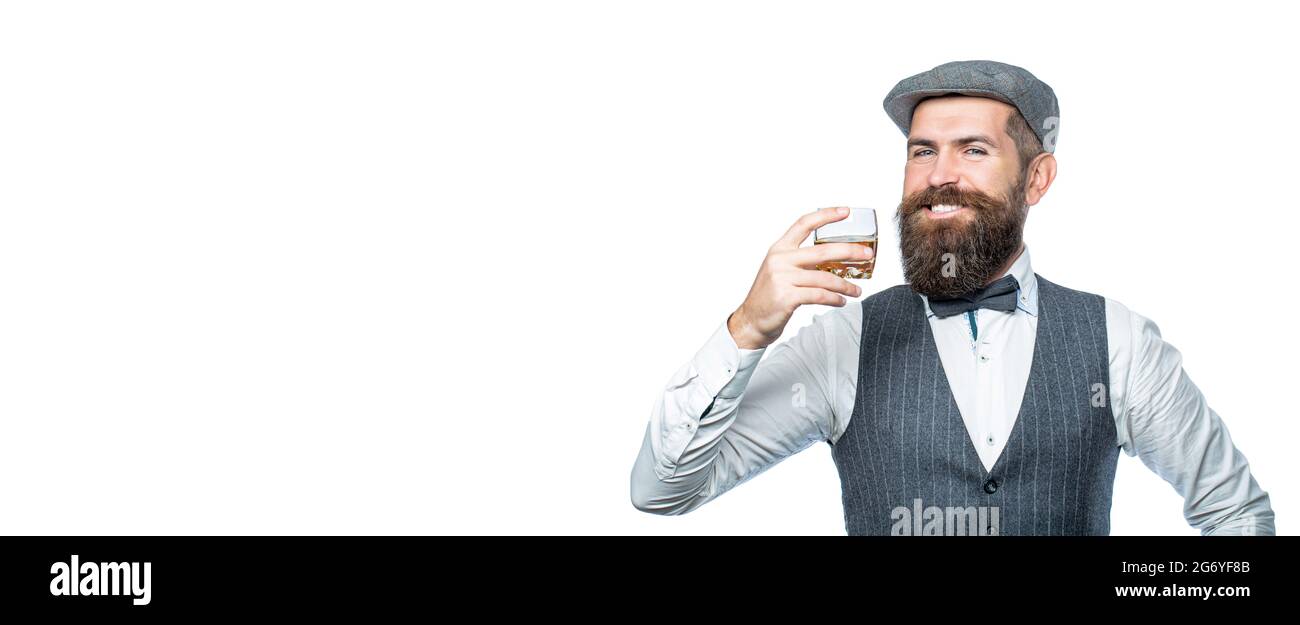 Stylish rich man holding a glass of old whisky. Bearded gentleman drink cognac. Sipping finest whiskey. Portrait of man with thick beard. Macho Stock Photo