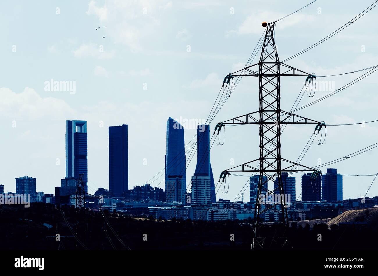 Power line juxtaposition with Madrid, Spain Cuatro Torres district skyline in the background Stock Photo