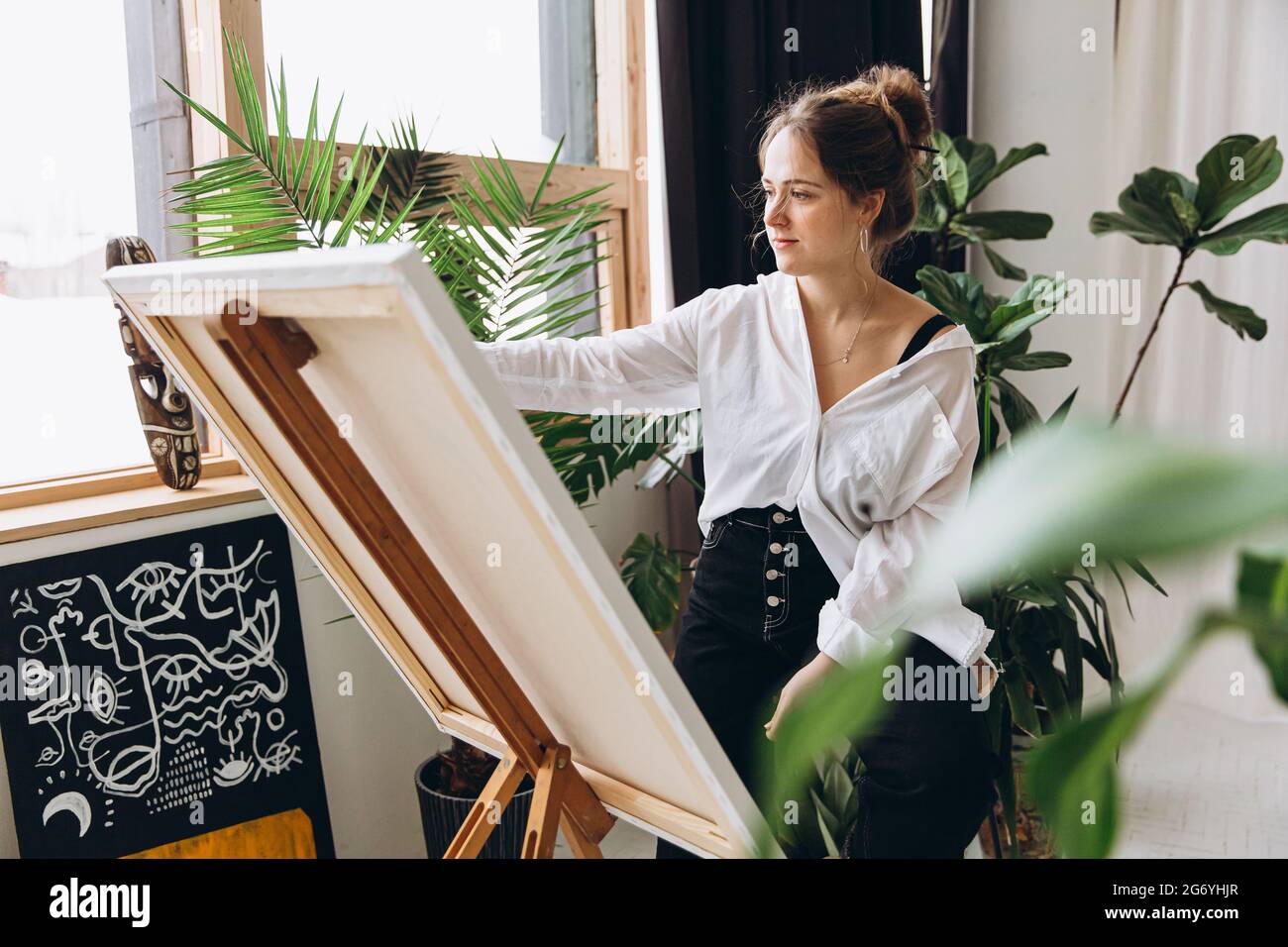 Female artist using brush and color palette for painting Stock Photo ...