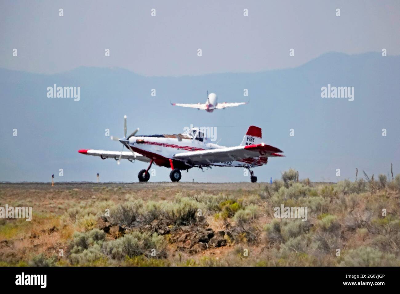 An Air Tractor carrying the fire boss, and a Coulson Flying Tanker 737 loaded with fire retardent, take off in 114 degree heat from the Redmond, Orego Stock Photo