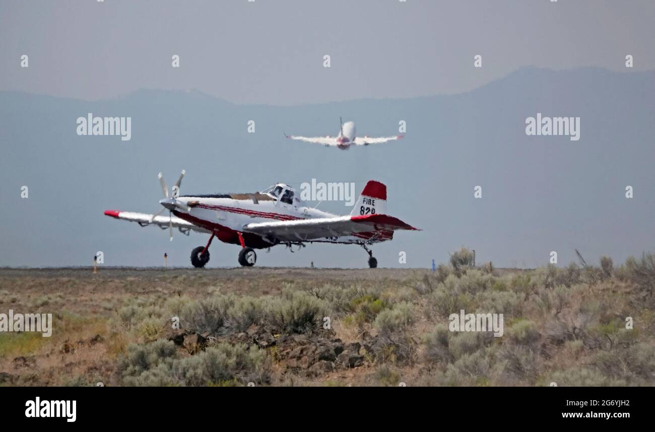 An Air Tractor carrying the fire boss, and a Coulson Flying Tanker 737 loaded with fire retardent, take off in 114 degree heat from the Redmond, Orego Stock Photo