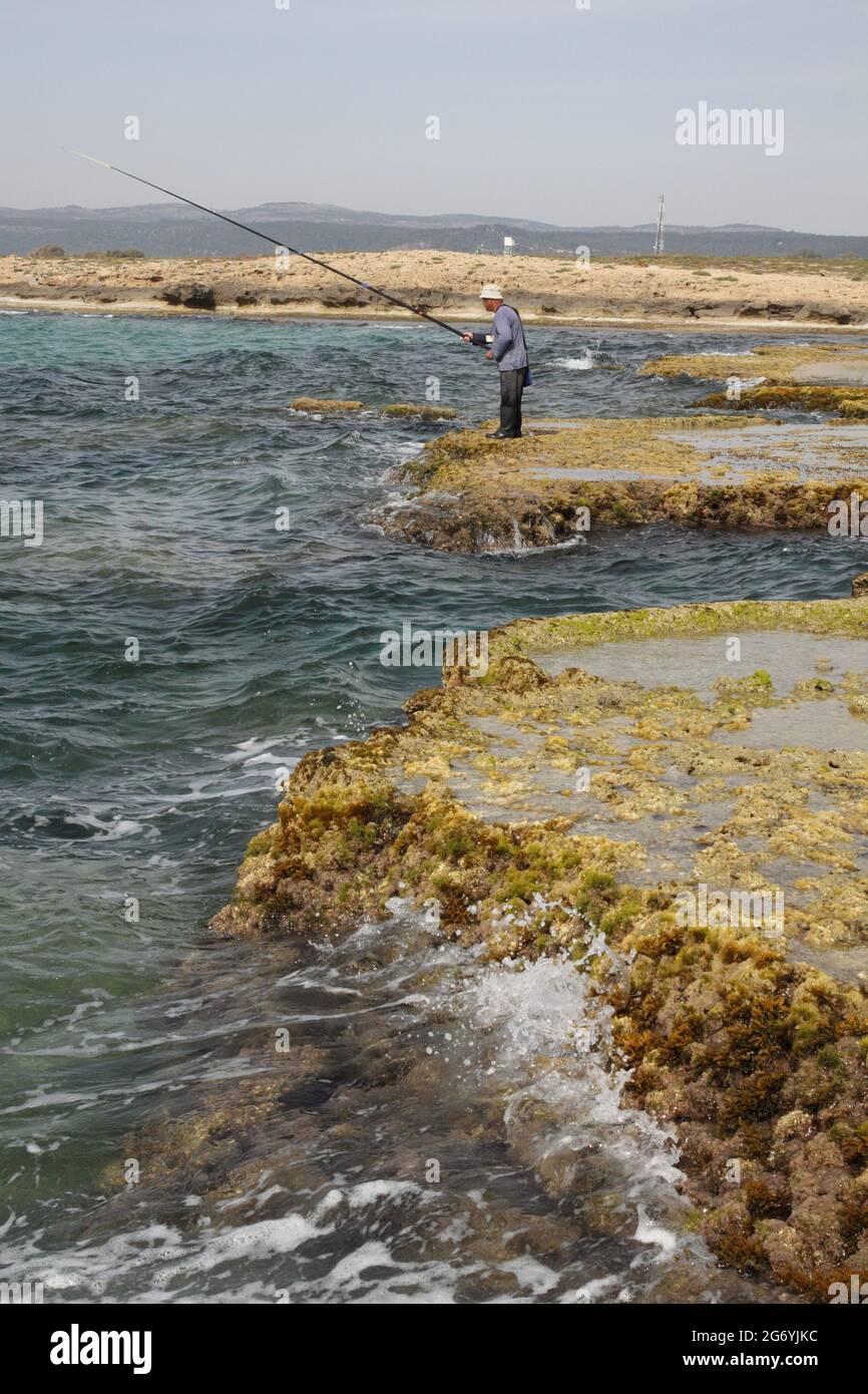 Man standing on rocks fishing hi-res stock photography and images