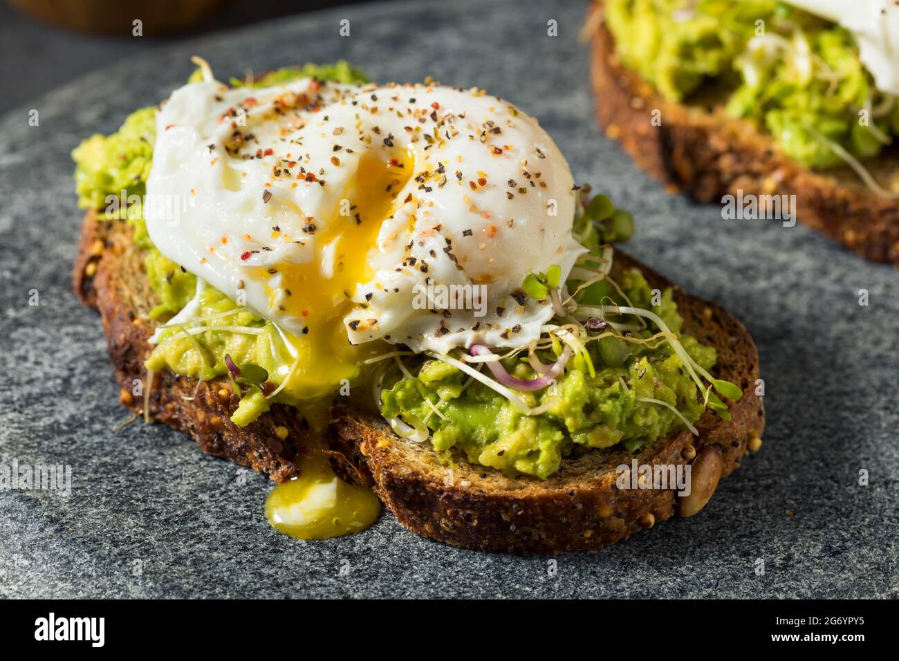 Homemade Healthy Avocado Toast with Poached Egg and Sprouts Stock Photo