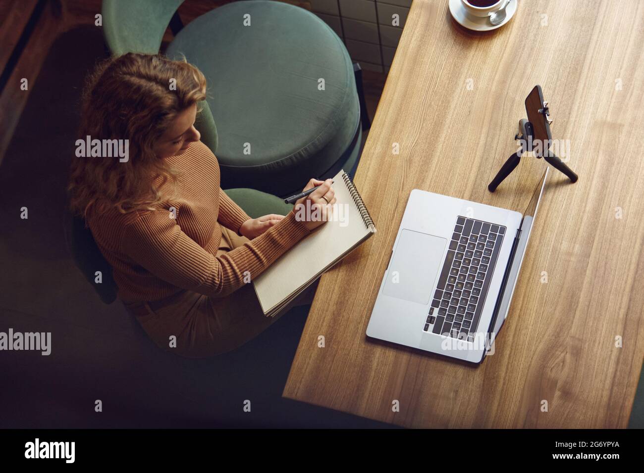 Female freelancer using laptop and smartphone for work Stock Photo